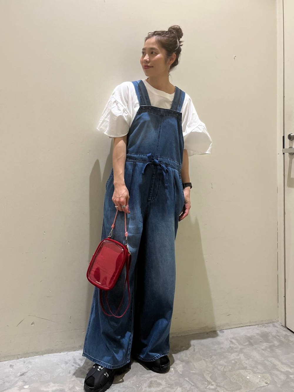 ホワイト系のTシャツ/カットソー、ブラック系のサンダル、レッド系のショルダーバッグを着用したレディースの春コーディネートの1枚目の写真