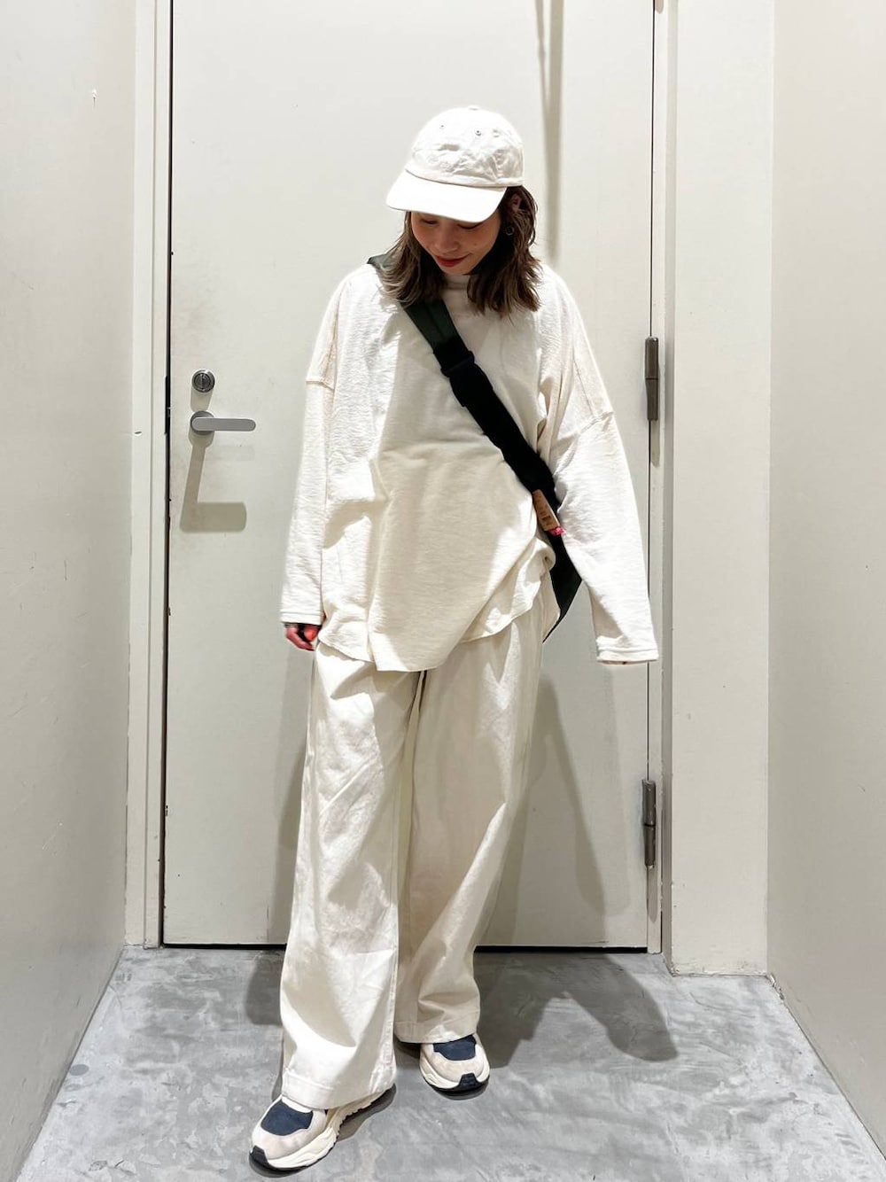 ベージュ系のその他パンツ、ベージュ系のTシャツ/カットソー、グリーン系のショルダーバッグを着用したレディースの冬コーディネートの1枚目の写真