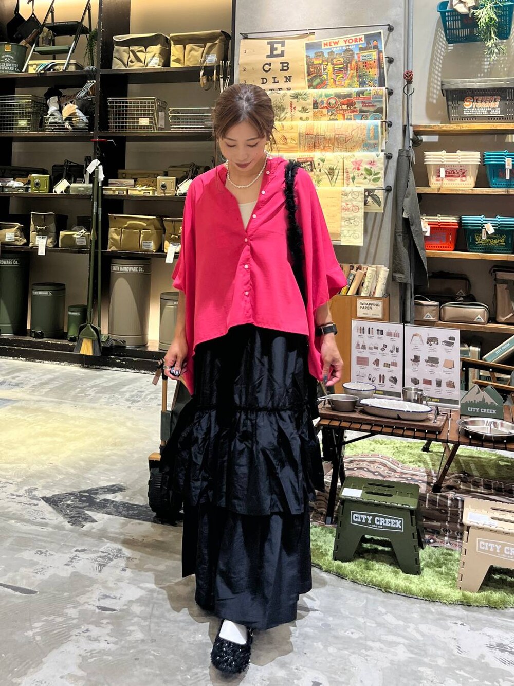 ブラック系のバレエシューズ、ブラック系のスカート、ベージュ系のキャミソールを着用したレディースの夏コーディネートの1枚目の写真