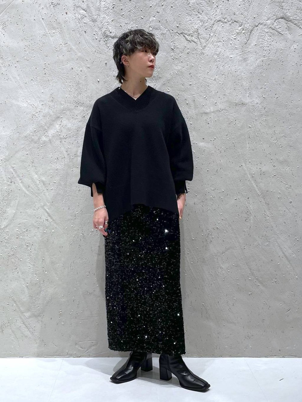 ブラック系のパンプス、ブラック系のニット/セーター、ブラック系のスカートを着用したレディースの秋コーディネートの1枚目の写真