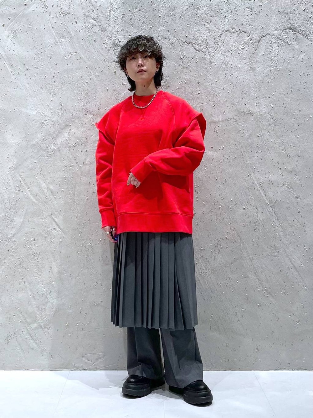 グレー系のその他パンツ、ブラック系のブーツ、レッド系のスウェットを着用したレディースの冬コーディネートの1枚目の写真