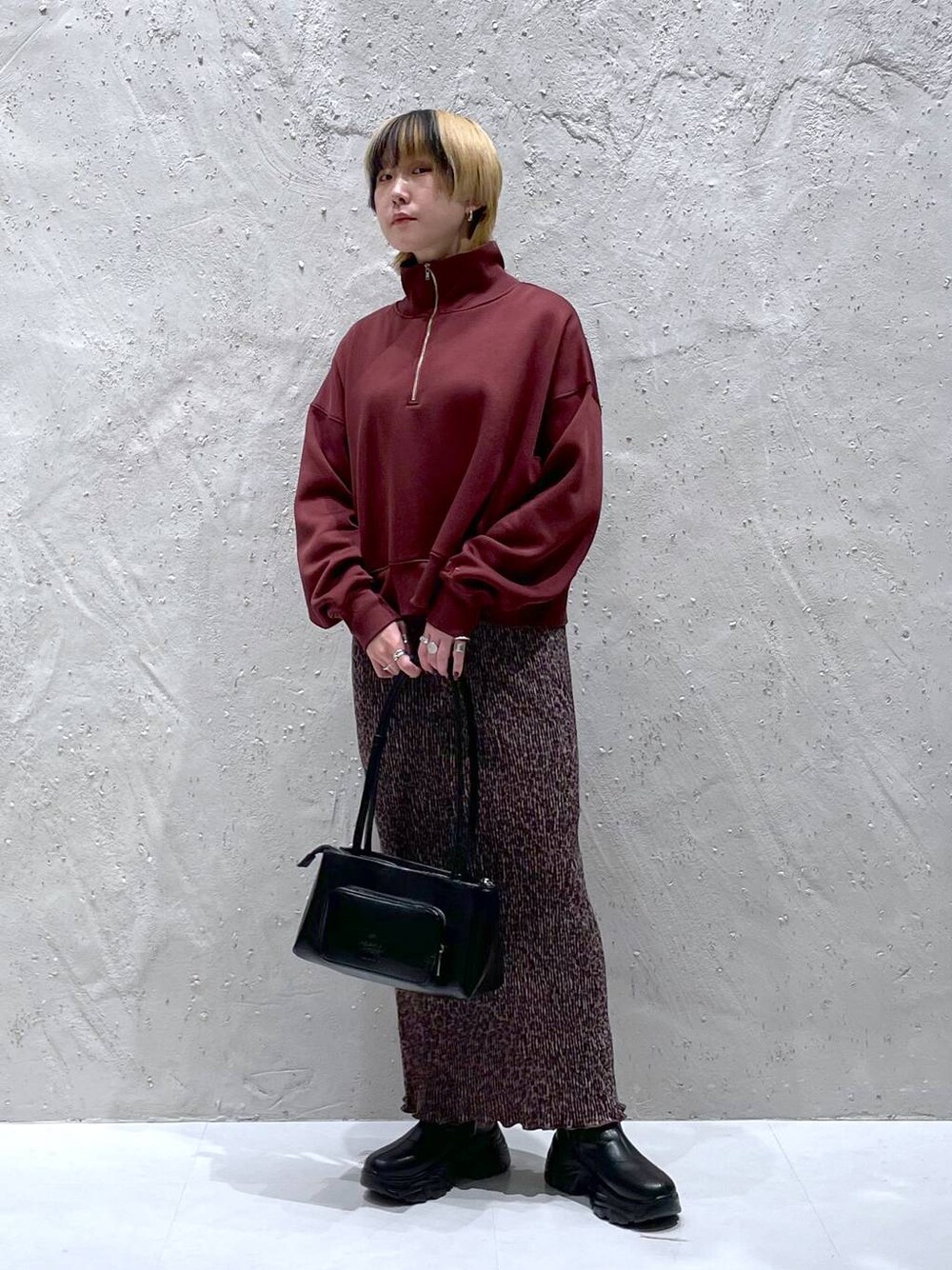 ブラック系のブーツ、ブラック系のショルダーバッグ、その他のスカートを着用したレディースの秋コーディネートの1枚目の写真