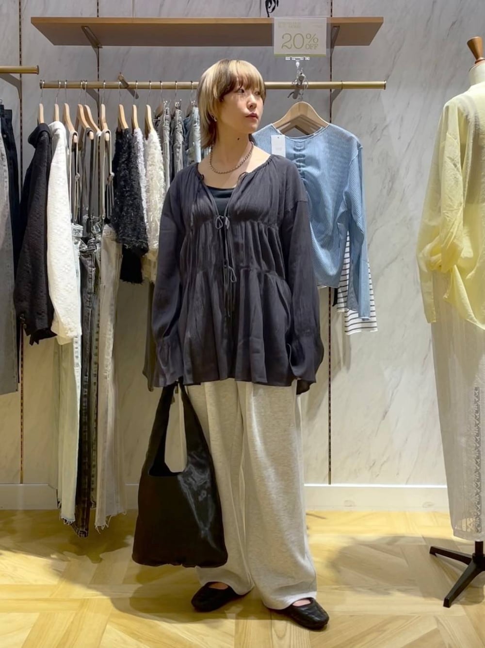 グレー系のシャツ/ブラウス、ブラック系のスニーカー、グレー系のスウェットパンツを着用したレディースの春コーディネートの1枚目の写真