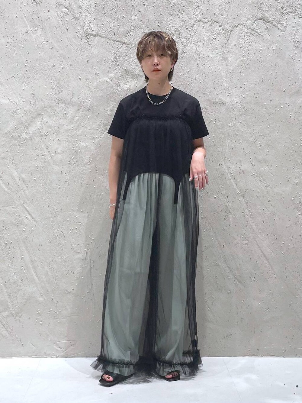 グリーン系のスラックス、ブラック系のTシャツ/カットソー、ブラック系のサロペット/オーバーオールを着用したレディースの夏コーディネートの1枚目の写真