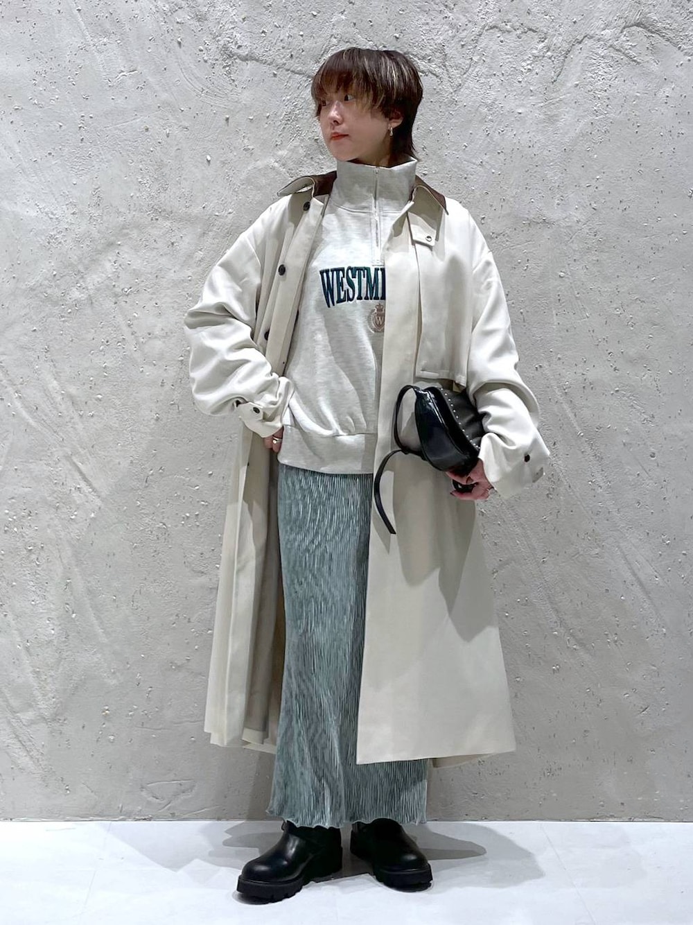 ブラック系のショルダーバッグ、ホワイト系のスウェット、ホワイト系のステンカラーコートを着用したレディースの秋コーディネートの1枚目の写真