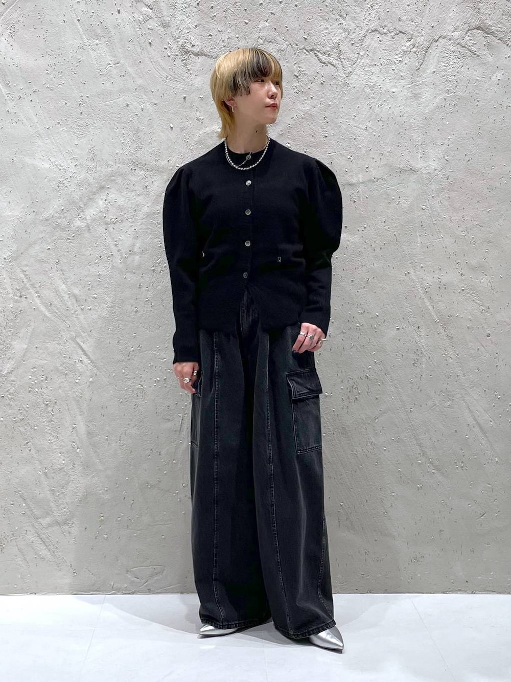 ブラック系のデニムパンツ、シルバー系のブーツ、ブラック系のカーディガン/ボレロを着用したレディースの秋コーディネートの1枚目の写真