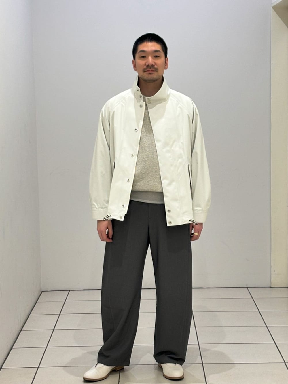 ホワイト系のその他アウター、グレー系のスラックス、グレー系のスウェットを着用したメンズの春コーディネートの1枚目の写真