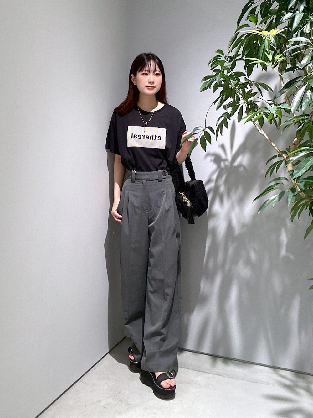 ブラック系のTシャツ/カットソー、グレー系のその他パンツ、ブラック系のハンドバッグを着用したレディースの夏コーディネートの1枚目の写真