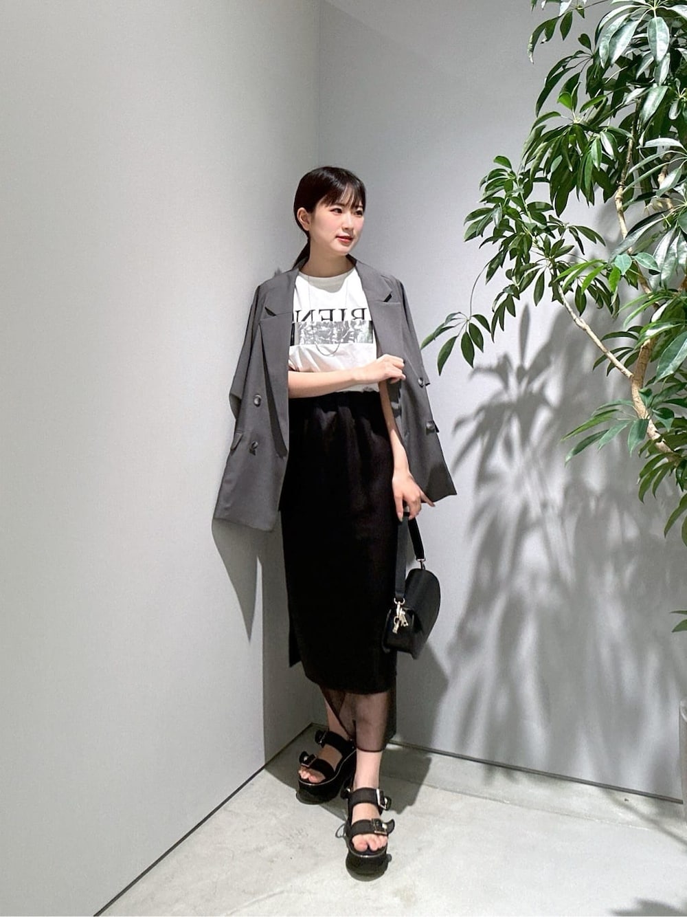 グレー系のテーラードジャケット、ホワイト系のTシャツ/カットソー、ブラック系のスカートを着用したレディースの夏コーディネートの1枚目の写真