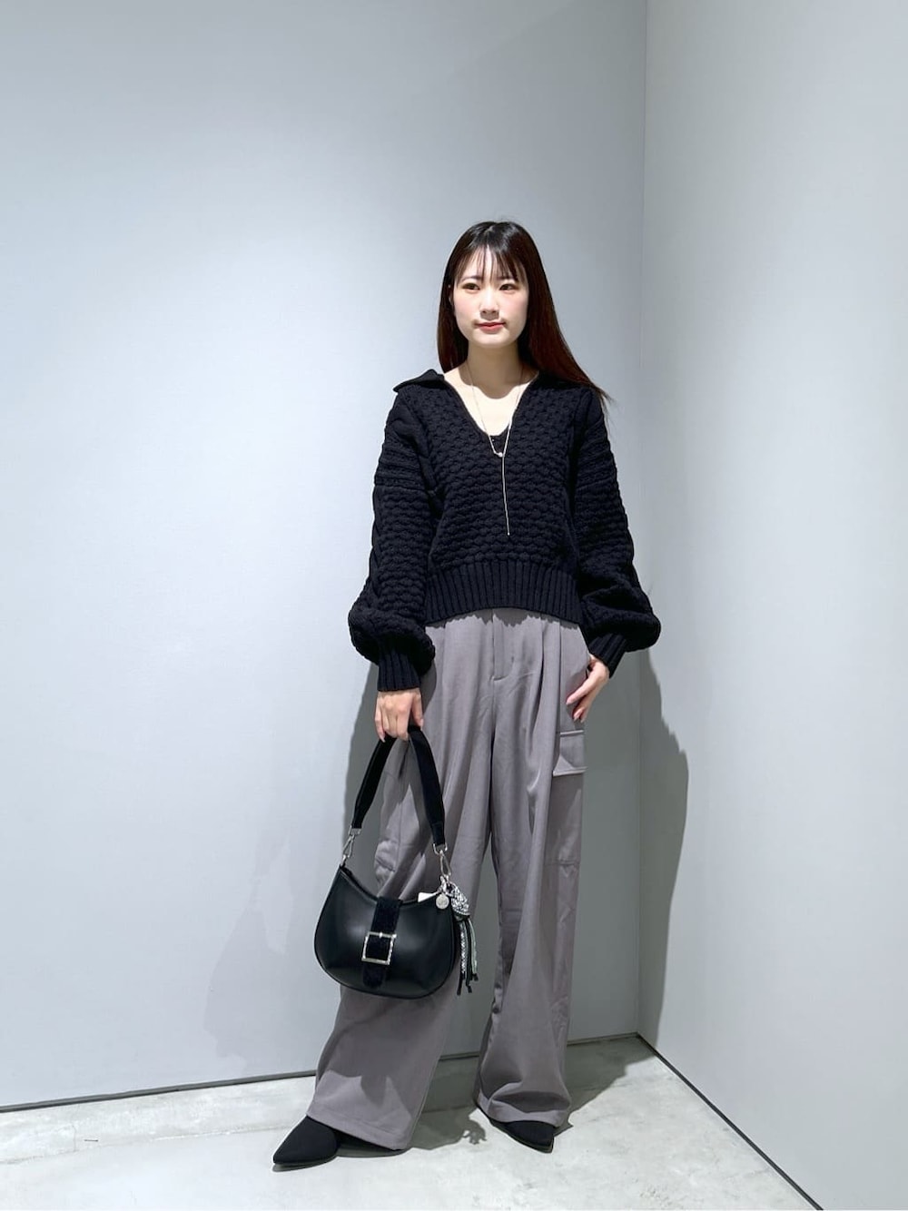 ブラック系のニット/セーター、グレー系のその他パンツ、ブラック系のショルダーバッグを着用したレディースの秋コーディネートの1枚目の写真