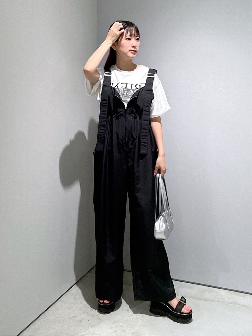 ホワイト系のTシャツ/カットソー、ブラック系のサロペット/オーバーオール、シルバー系のハンドバッグを着用したレディースの夏コーディネートの1枚目の写真