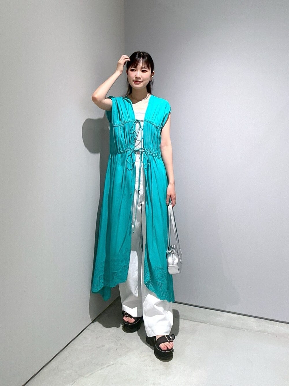 ブルー系のワンピース、ホワイト系のタンクトップ、ホワイト系のデニムパンツを着用したレディースの夏コーディネートの1枚目の写真