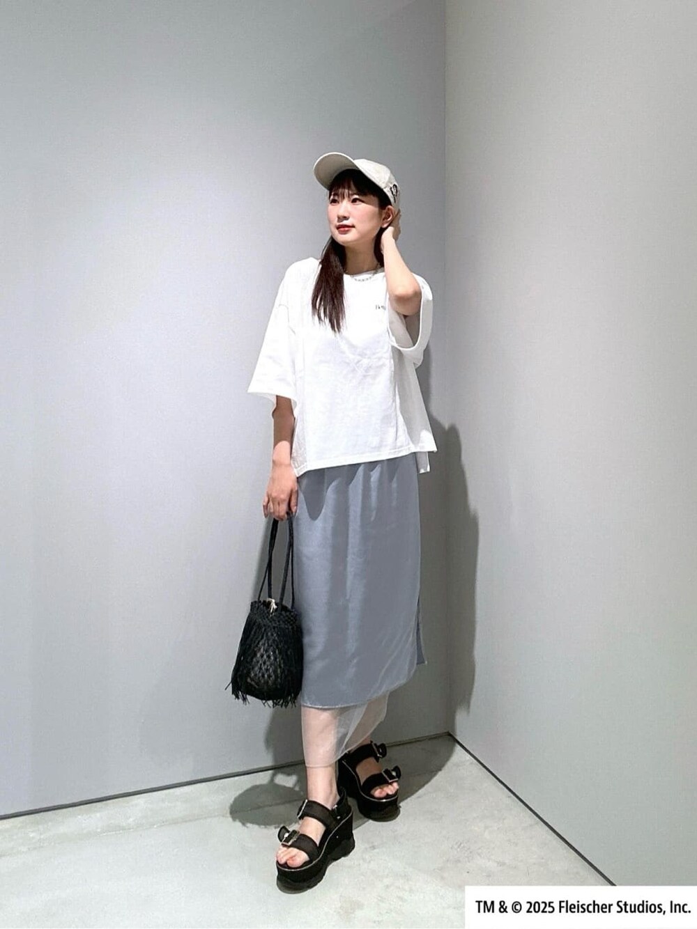 ホワイト系のTシャツ/カットソー、ブルー系のスカート、ブラック系のハンドバッグを着用したレディースの夏コーディネートの1枚目の写真