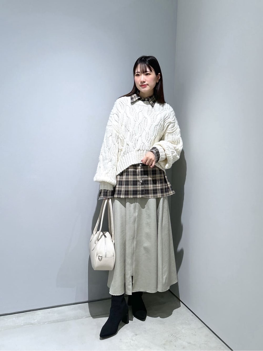 ホワイト系のニット/セーター、ベージュ系のシャツ/ブラウス、グリーン系のスカートを着用したレディースの冬コーディネートの1枚目の写真