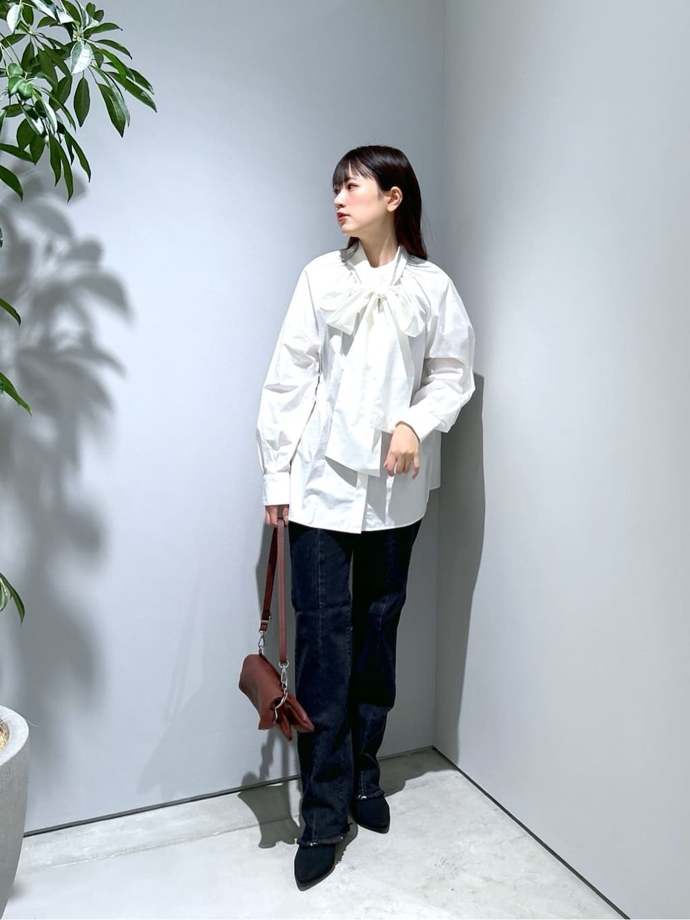 ホワイト系のシャツ/ブラウス、グレー系のデニムパンツ、ブラウン系のショルダーバッグを着用したレディースの秋コーディネートの1枚目の写真