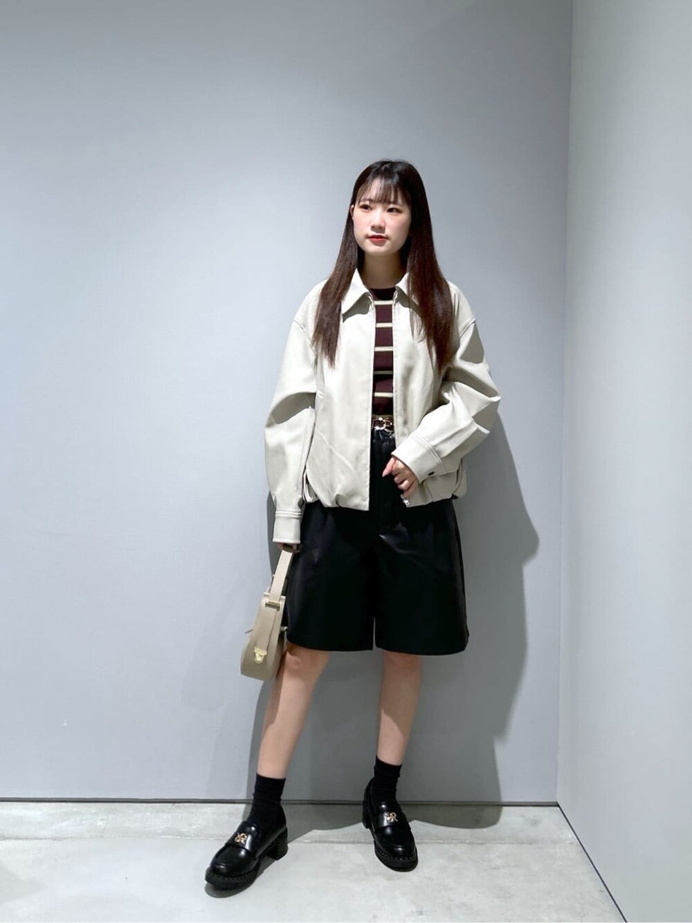 ベージュ系のブルゾン、ブラック系のその他パンツ、ベージュ系のショルダーバッグを着用したレディースの秋コーディネートの1枚目の写真