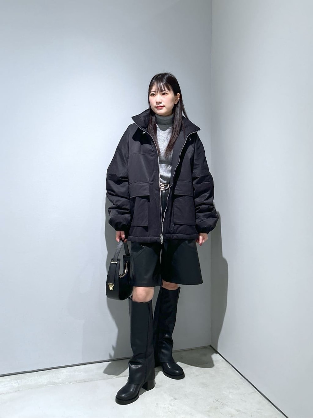 ブラック系のその他アウター、グレー系のニット/セーター、ブラック系のその他パンツを着用したレディースの冬コーディネートの1枚目の写真
