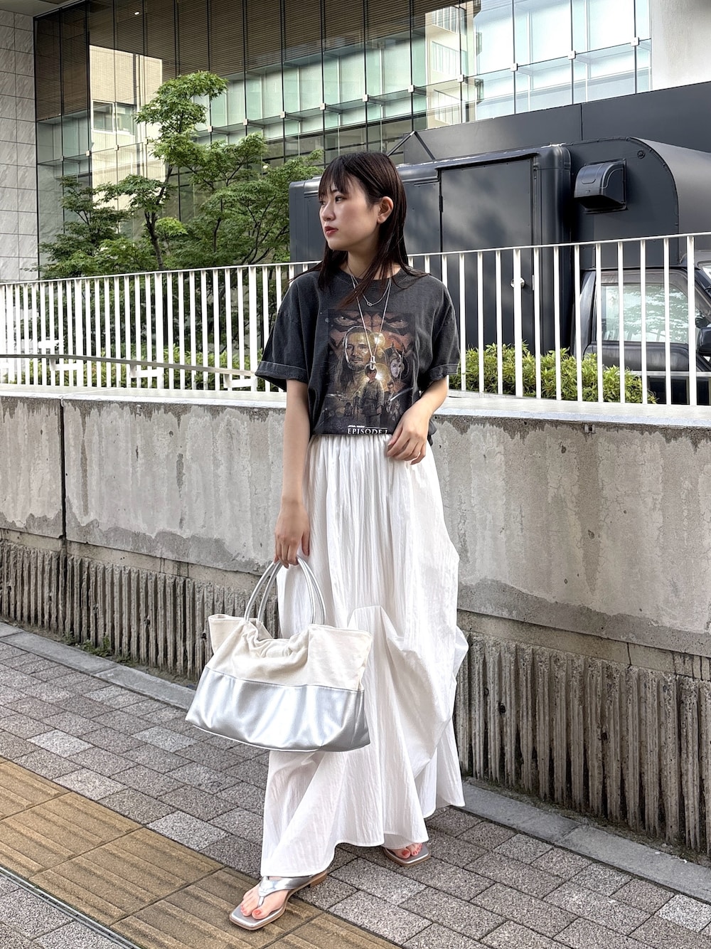 シルバー系のサンダル、グレー系のTシャツ/カットソー、シルバー系のトートバッグを着用したレディースの春コーディネートの1枚目の写真