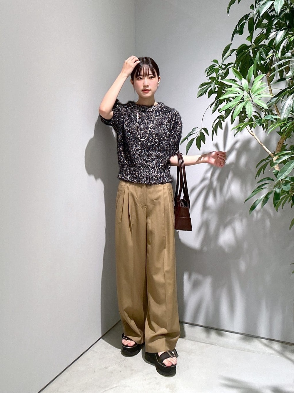 ブラック系のニット/セーター、イエロー系のその他パンツ、ブラウン系のショルダーバッグを着用したレディースの秋コーディネートの1枚目の写真