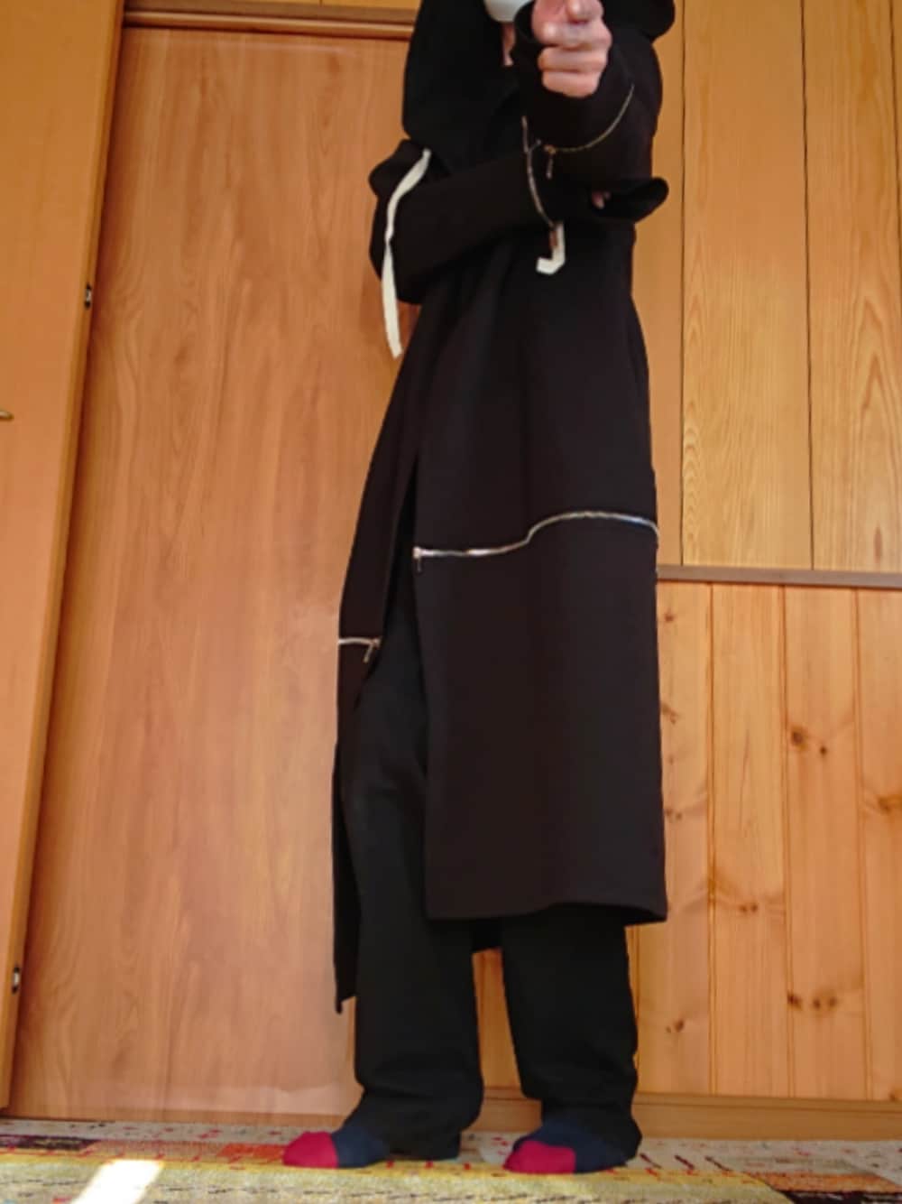 ブラック系のチェスターコートを着用したメンズの秋コーディネートの1枚目の写真