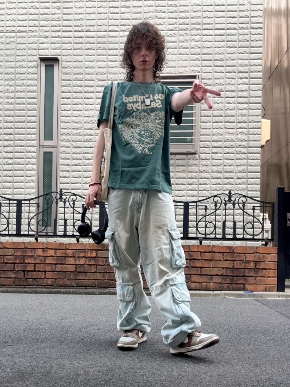 グリーン系のTシャツ/カットソー、ブルー系のカーゴパンツ、ベージュ系のトートバッグを着用したメンズの秋コーディネートの1枚目の写真