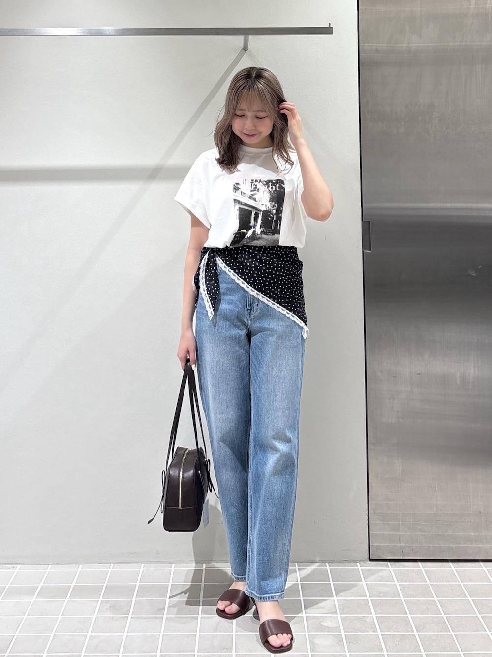 ホワイト系のTシャツ/カットソー、ブルー系のデニムパンツ、ブラウン系のボストンバッグを着用したレディースの夏コーディネートの1枚目の写真
