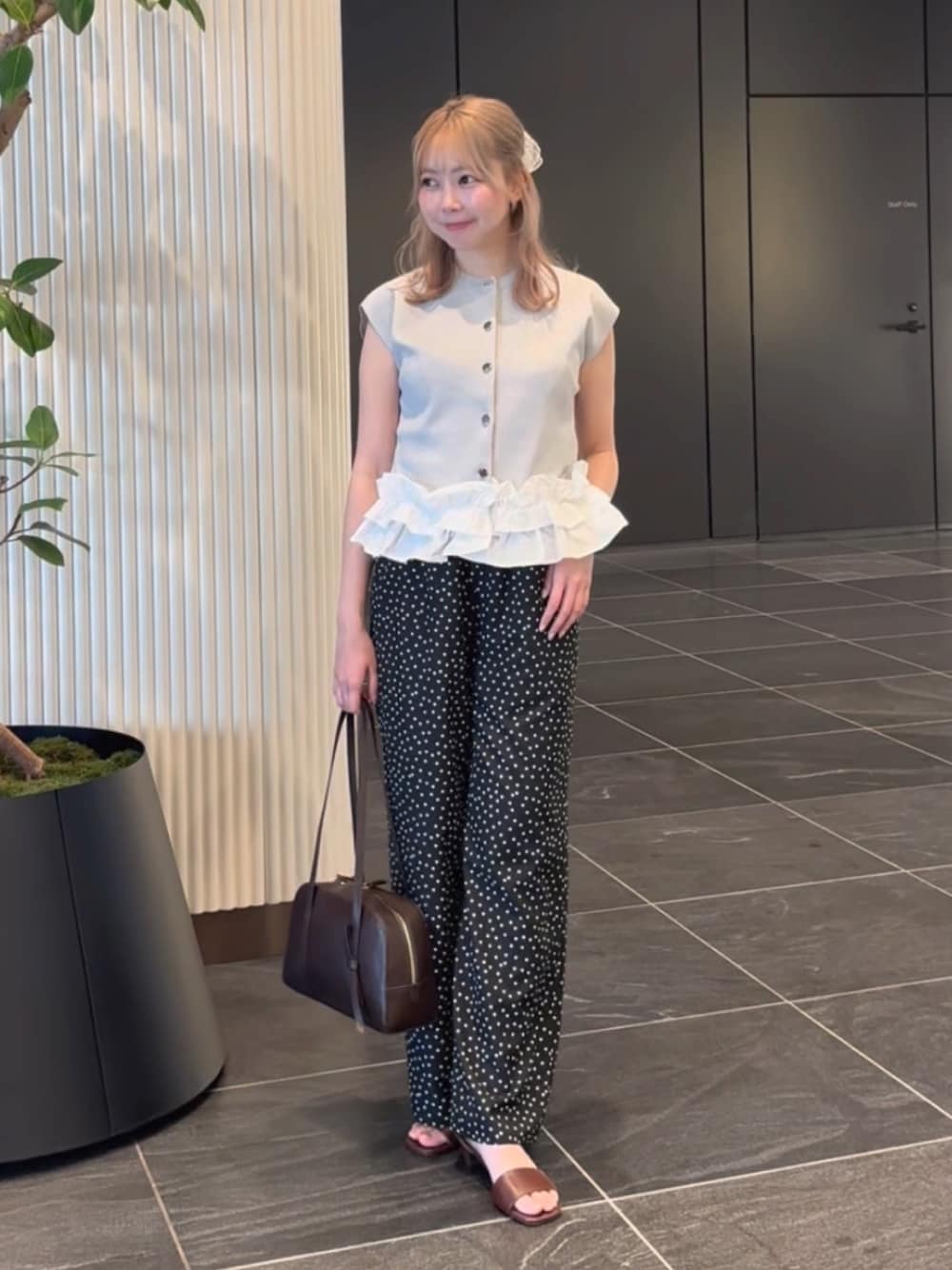 グレー系のベスト、ブラック系のその他パンツ、ブラウン系のサンダルを着用したレディースの夏コーディネートの1枚目の写真