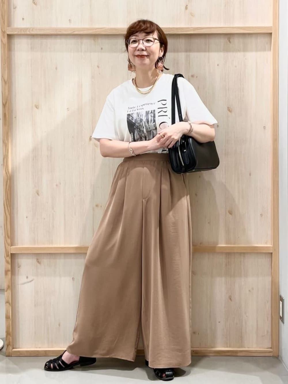 ホワイト系のTシャツ/カットソー、ベージュ系のその他パンツ、ブラック系のトートバッグを着用したレディースの夏コーディネートの1枚目の写真