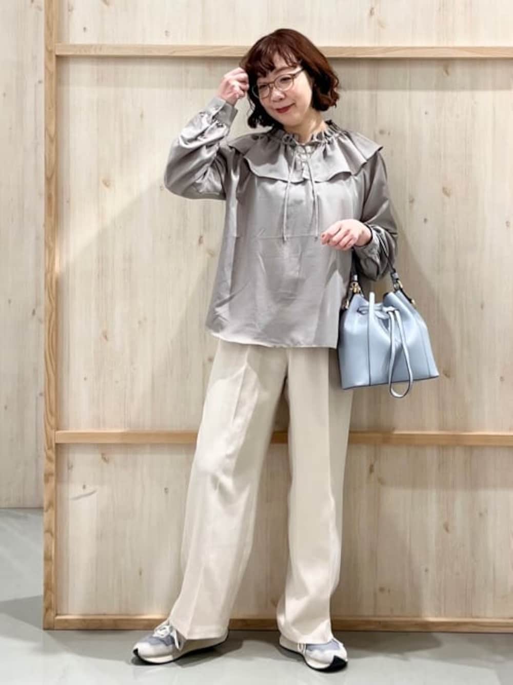 ベージュ系のシャツ/ブラウス、ベージュ系のその他パンツ、ブルー系のショルダーバッグを着用したレディースの春コーディネートの1枚目の写真