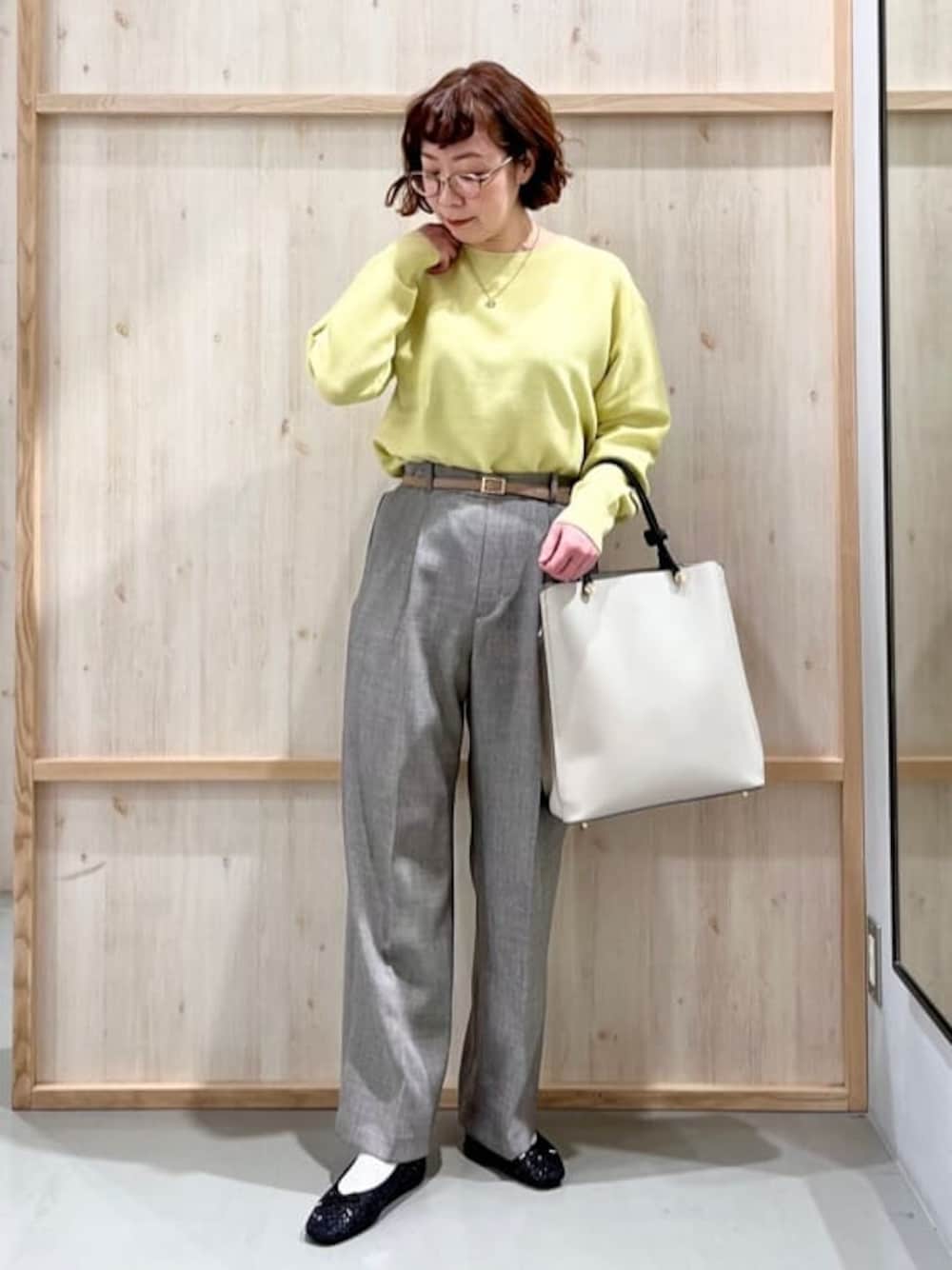 イエロー系のニット/セーター、グレー系のその他パンツ、グレー系のトートバッグを着用したレディースの冬コーディネートの1枚目の写真