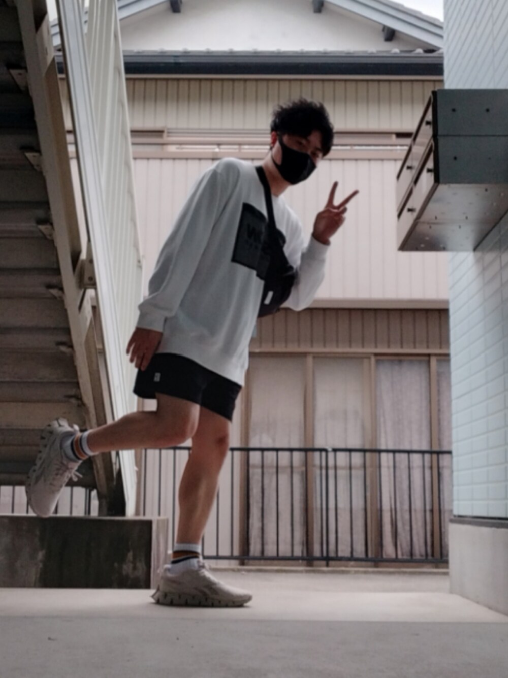 ホワイト系のニット/セーター、ブラック系のスウェットパンツ、ホワイト系のスニーカーを着用したメンズの春コーディネートの1枚目の写真