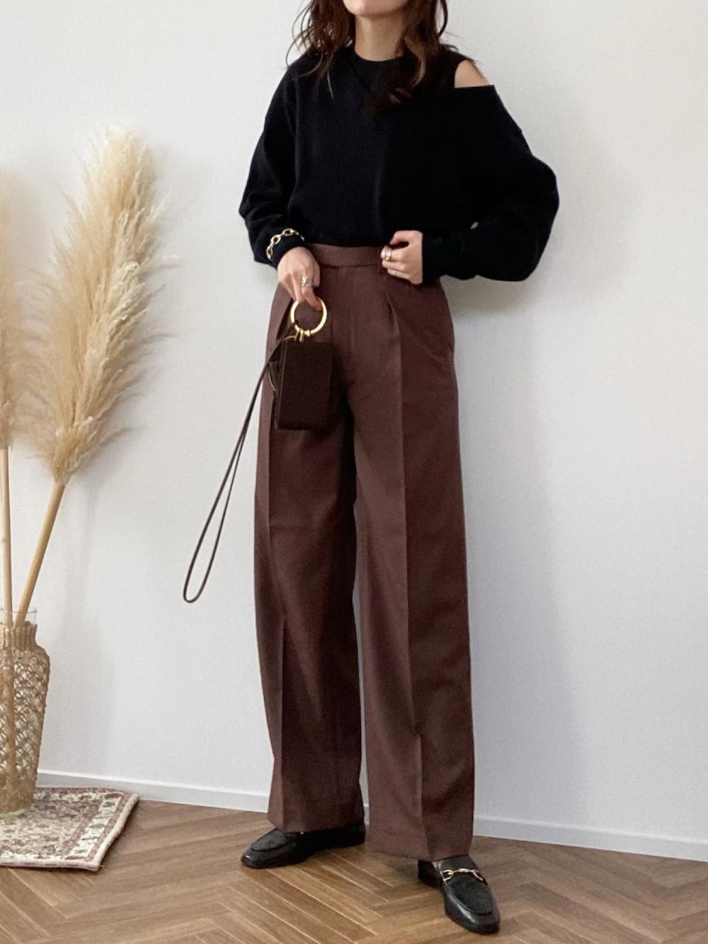 ブラック系のTシャツ/カットソー、ブラウン系のパンツ、ブラウン系のハンドバッグを着用したレディースの秋コーディネートの1枚目の写真