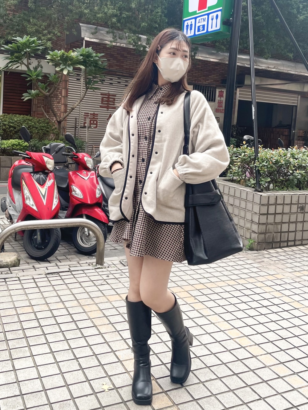 ブラック系のブーツ、ベージュ系のワンピース、ブラック系のドラムバッグを着用したレディースの秋コーディネートの1枚目の写真