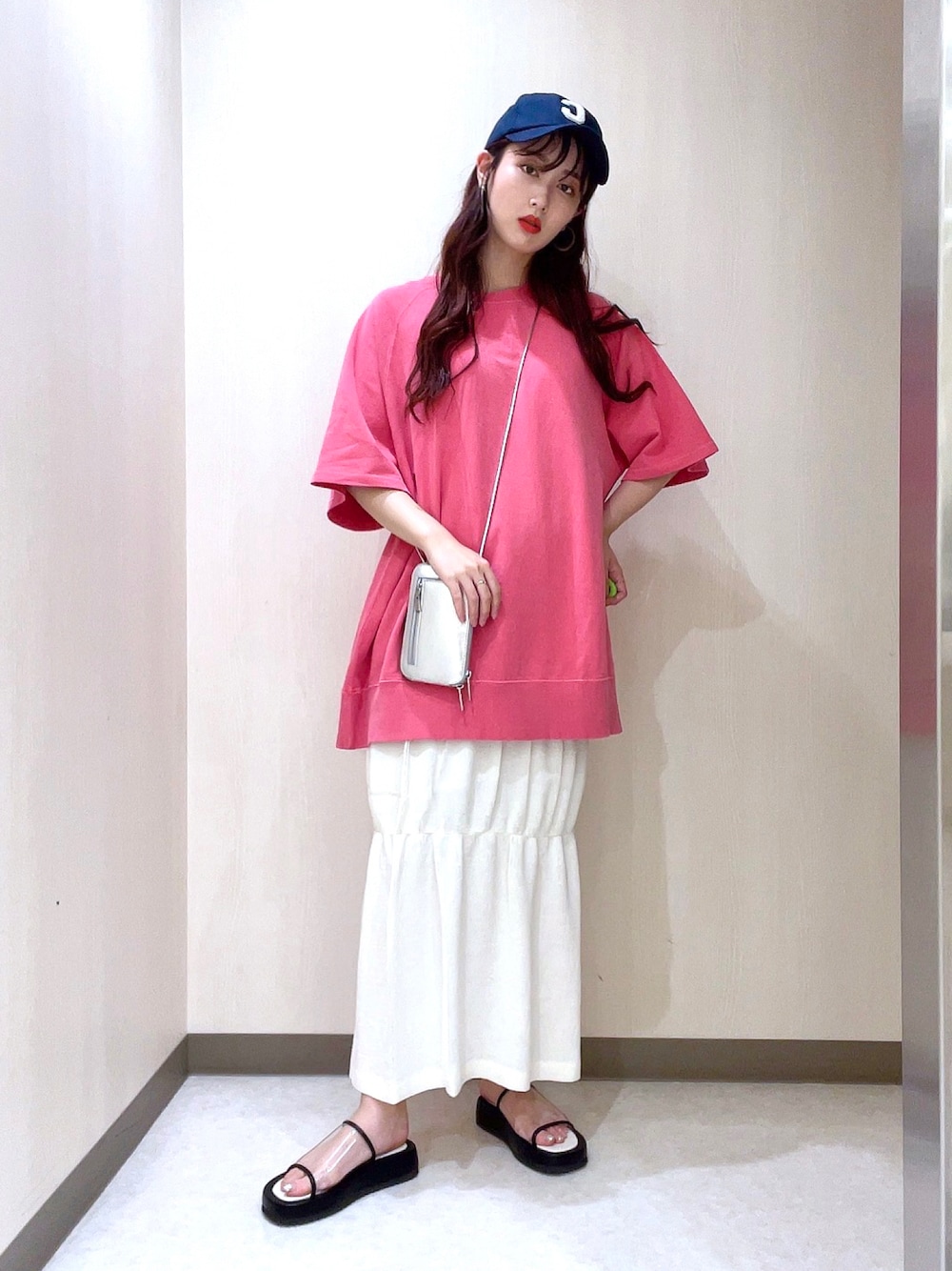 ピンク系のTシャツ/カットソー、ホワイト系のスカート、シルバー系のショルダーバッグを着用したレディースの夏コーディネートの1枚目の写真