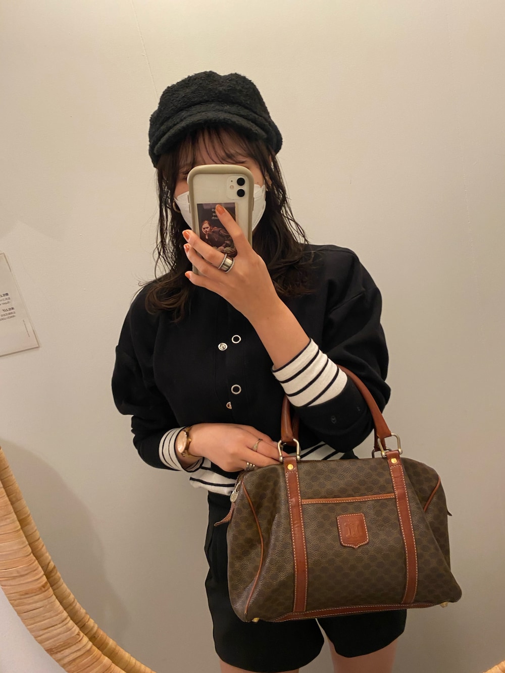 ブラウン系のボストンバッグ、ブラック系のカーディガン/ボレロを着用したレディースの秋コーディネートの1枚目の写真