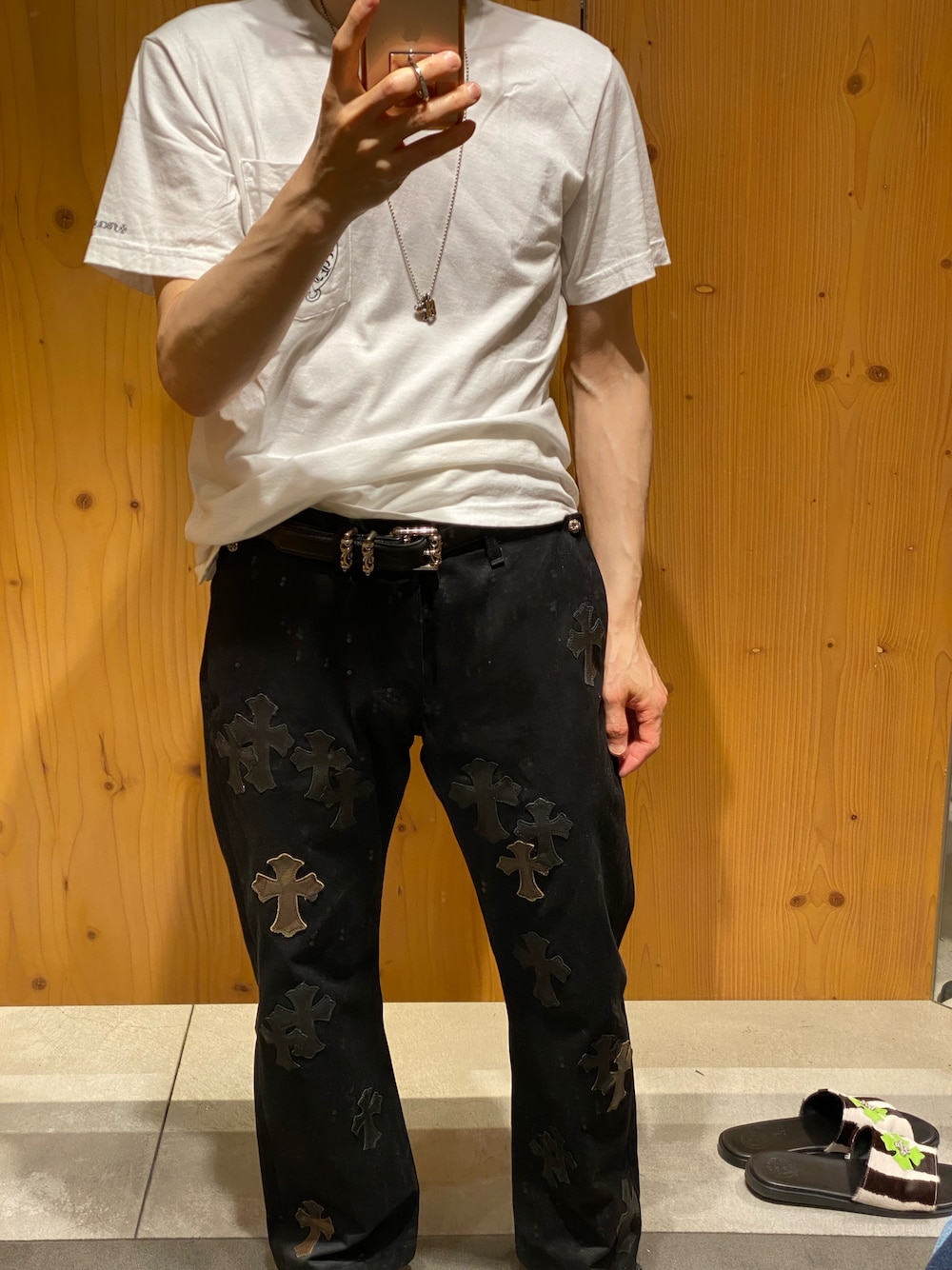 ホワイト系のTシャツ/カットソー、ブラック系のチノパンツ、ブラック系のサンダルを着用したメンズの夏コーディネートの1枚目の写真