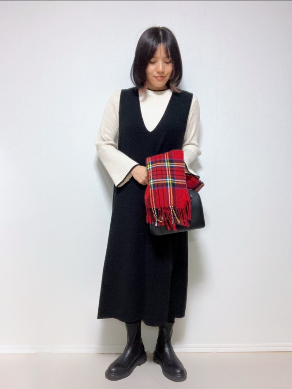 ホワイト系のニット/セーター、ブラック系のワンピース、ブラック系のバッグを着用したレディースの冬コーディネートの1枚目の写真