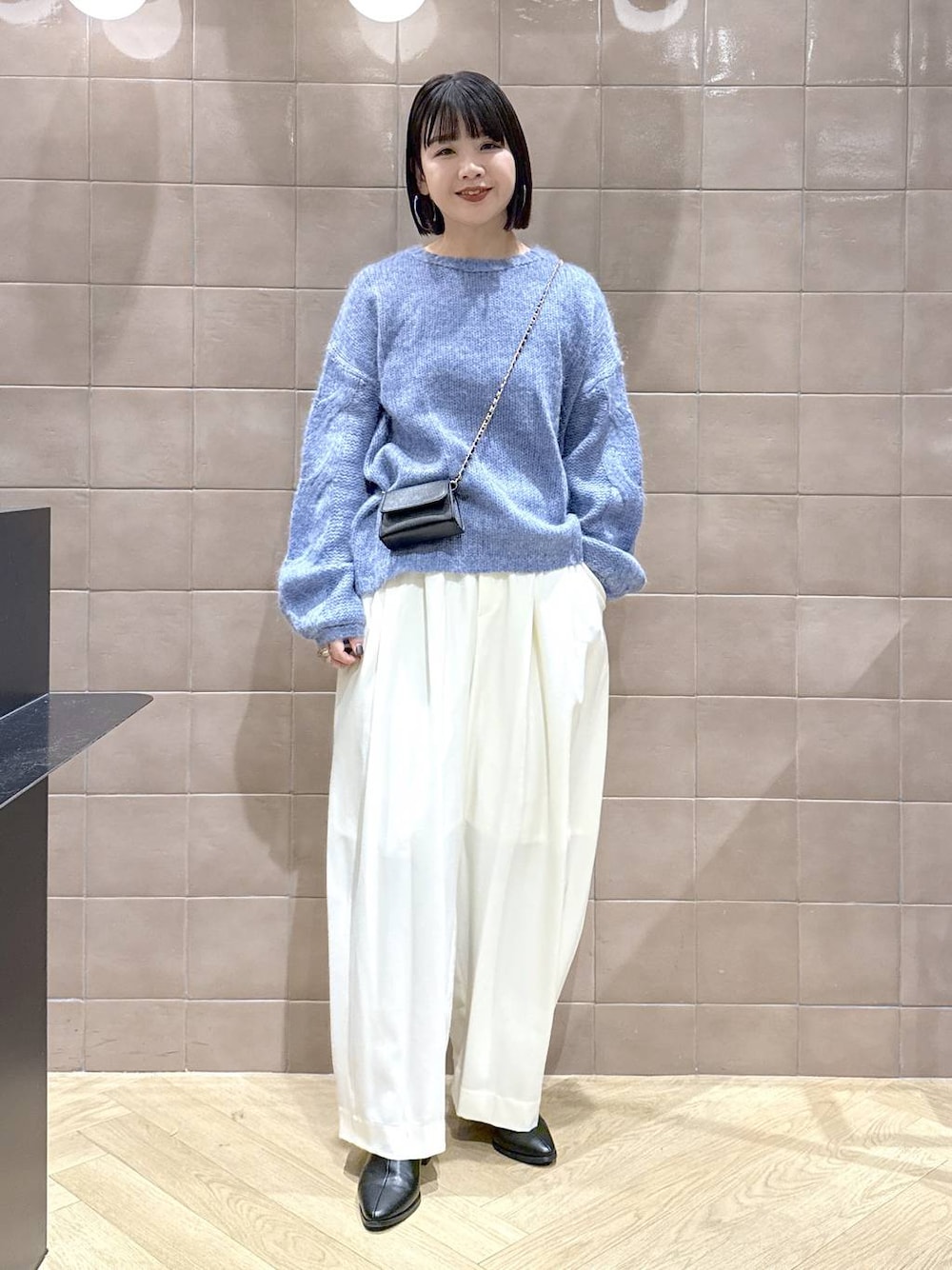 ホワイト系のスラックス、グレー系のTシャツ/カットソー、ブラック系のブーツを着用したレディースの秋コーディネートの1枚目の写真