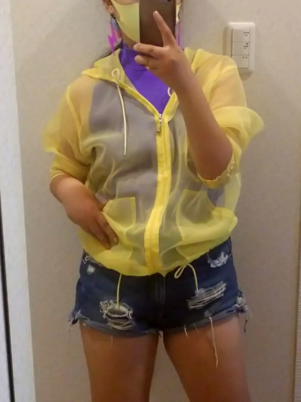 イエロー系のパーカー、パープル系のその他トップス、パープル系のデニムパンツを着用したレディースの秋コーディネートの1枚目の写真