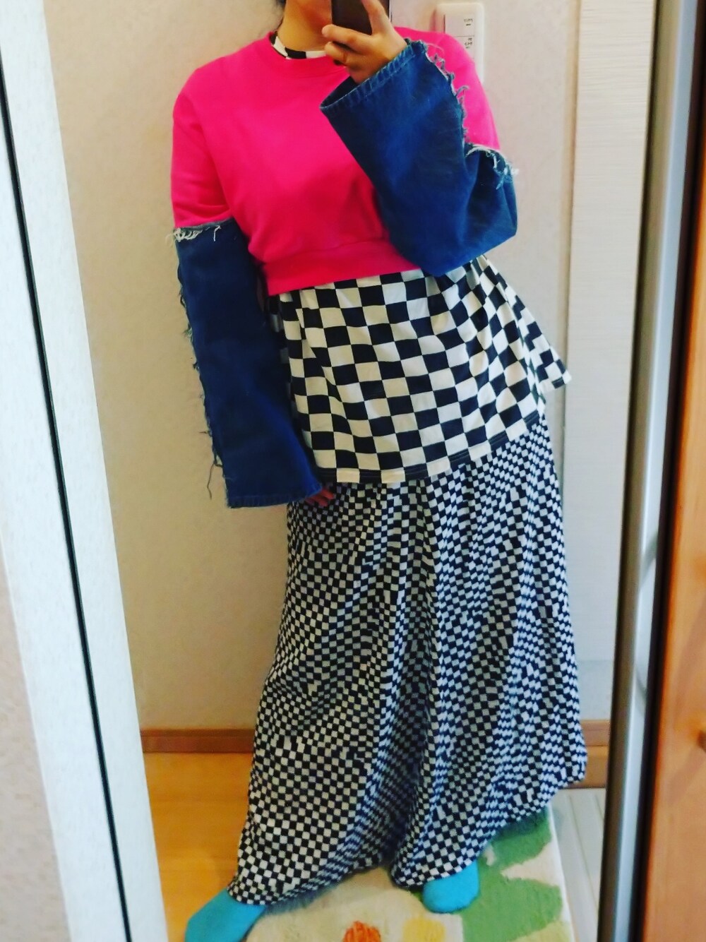 ピンク系のスウェット、ブラック系のTシャツ/カットソー、ブラック系のスカートを着用したレディースの春コーディネートの1枚目の写真