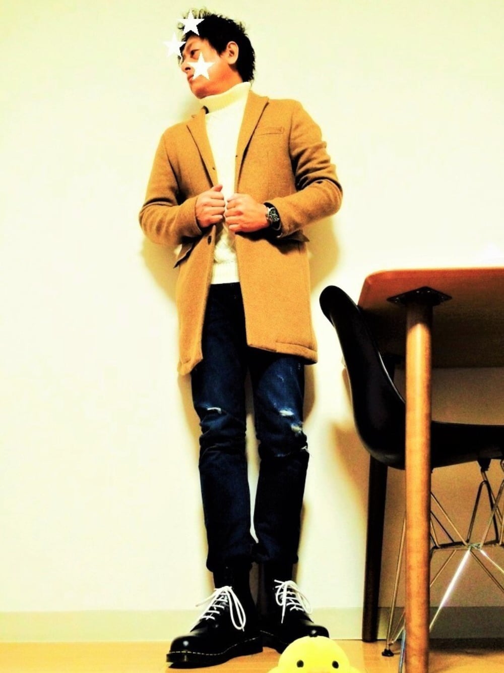 ベージュ系のチェスターコート、ホワイト系のニット/セーター、ブルー系のデニムパンツを着用したメンズの冬コーディネートの1枚目の写真