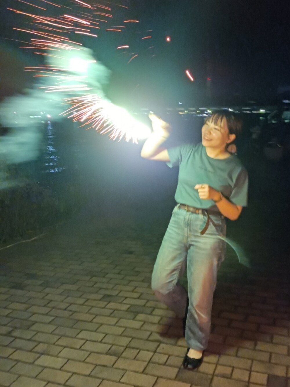 グリーン系のTシャツ/カットソー、ブルー系のデニムパンツ、ブラック系のバレエシューズを着用したレディースの秋コーディネートの1枚目の写真