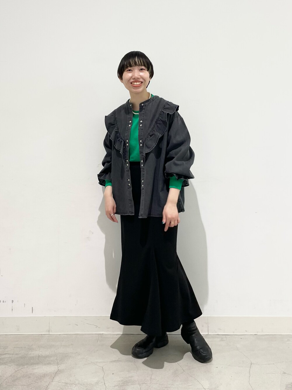 グリーン系のTシャツ/カットソー、ブラック系のシャツ/ブラウス、ブラック系のスカートを着用したレディースの冬コーディネートの1枚目の写真