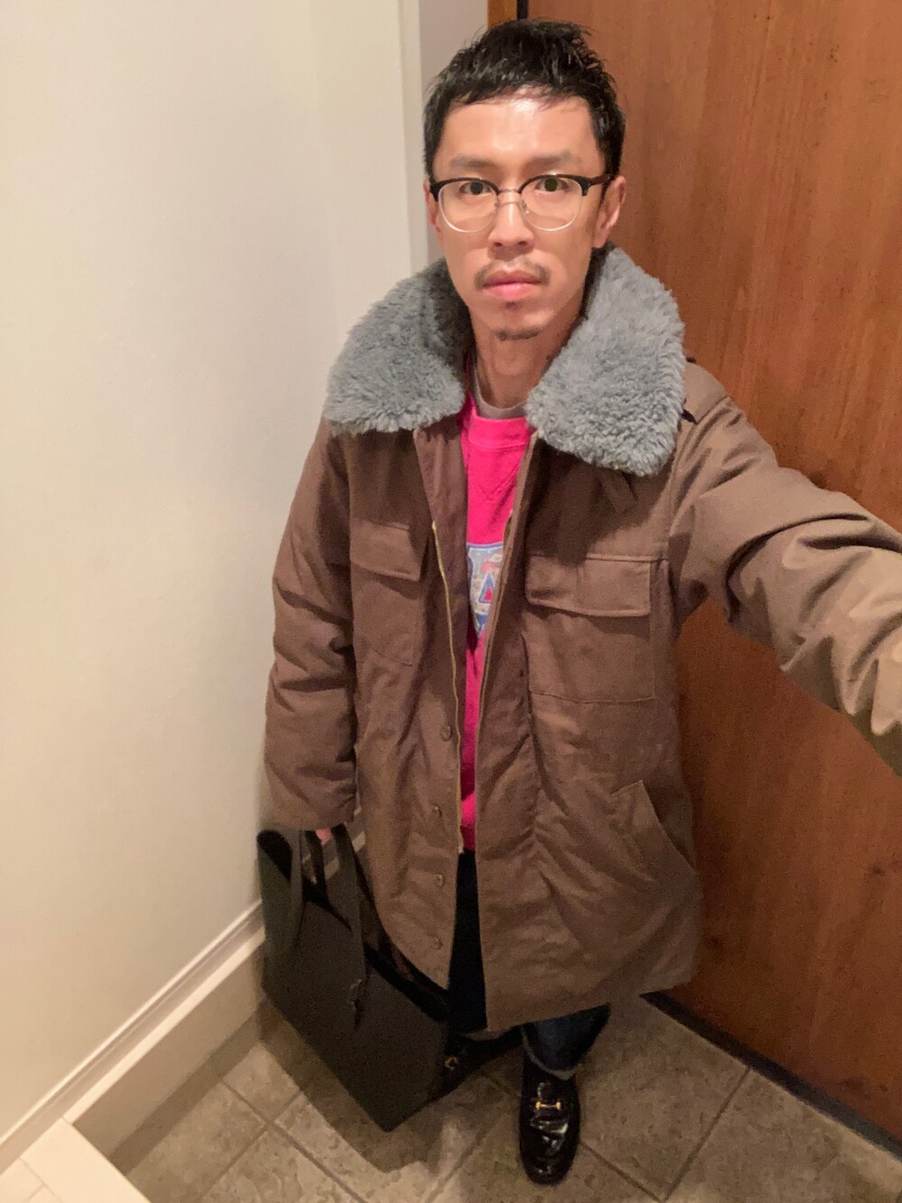 グリーン系のミリタリージャケット、ピンク系のスウェット、ブルー系のデニムパンツを着用したメンズの冬コーディネートの1枚目の写真