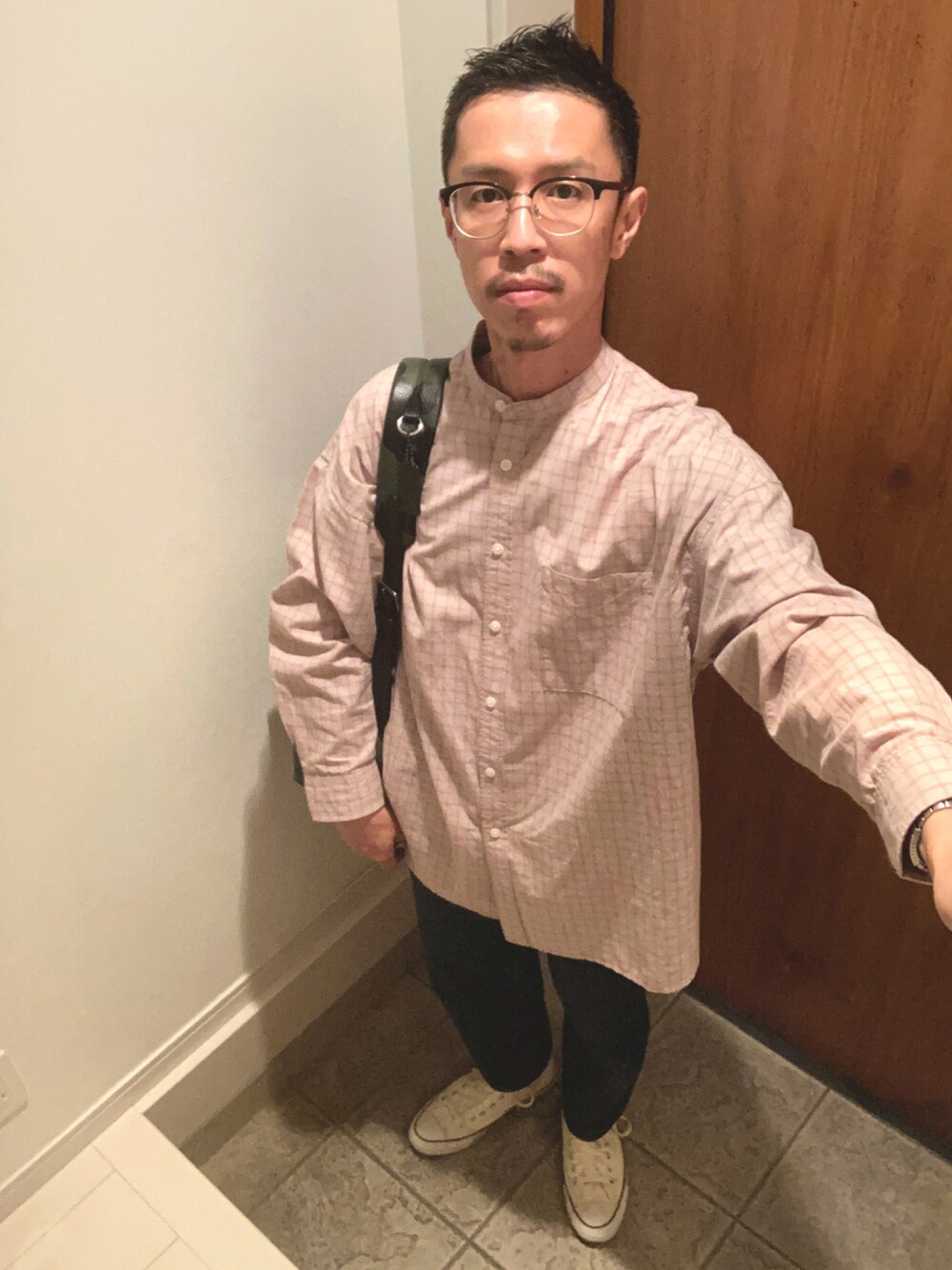 ブルー系のデニムパンツ、ベージュ系のシャツ/ブラウス、グリーン系のバックパック/リュックを着用したメンズの秋コーディネートの1枚目の写真