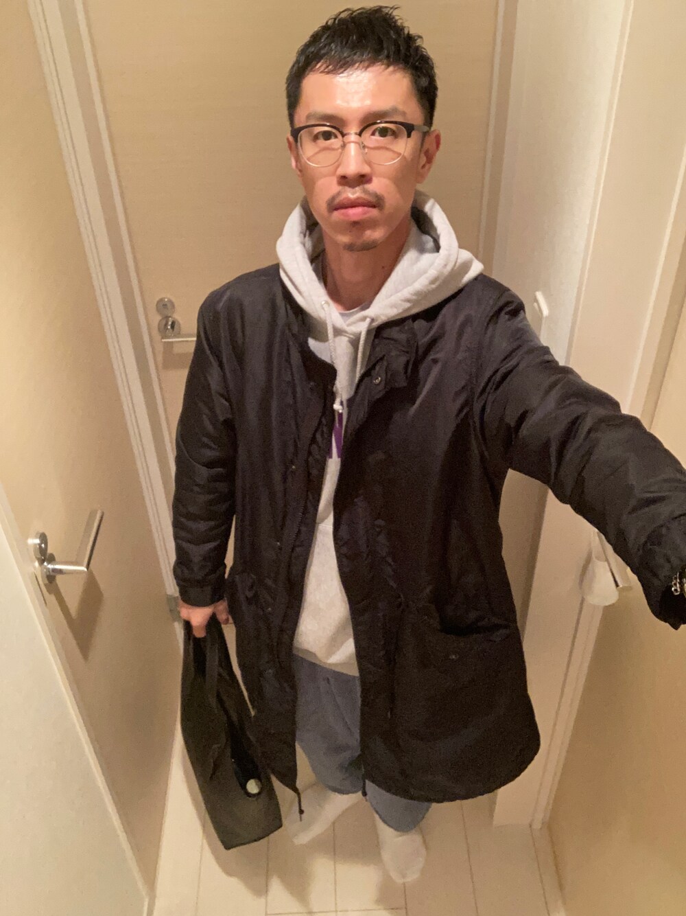 ホワイト系のスリッポン、ブラック系のミリタリージャケット、ブルー系のパンツを着用したメンズの冬コーディネートの1枚目の写真