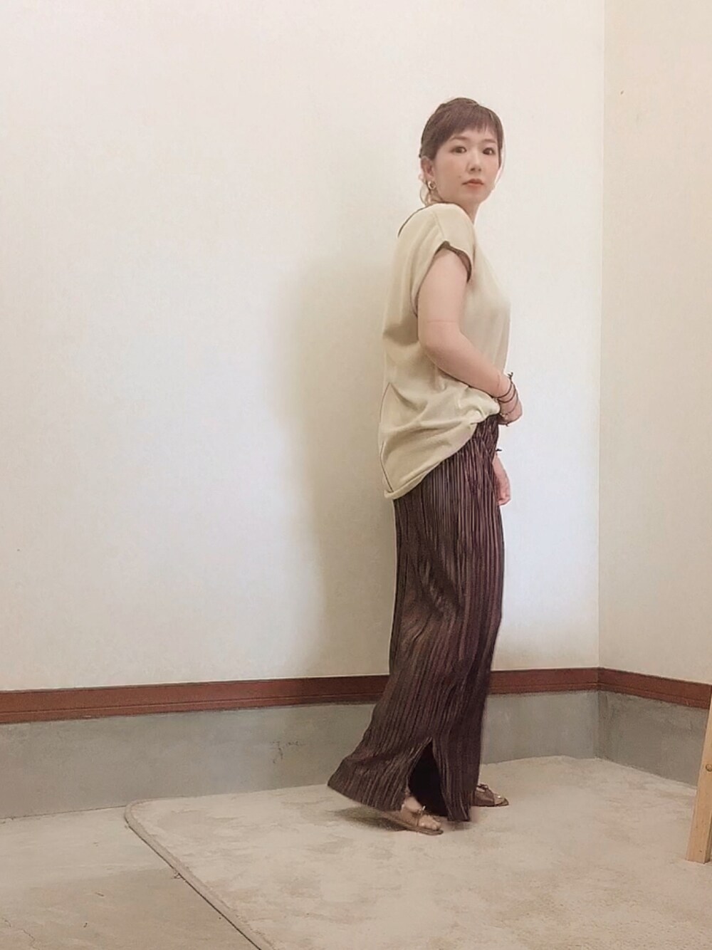 ベージュ系のTシャツ/カットソーを着用したレディースの夏コーディネートの1枚目の写真