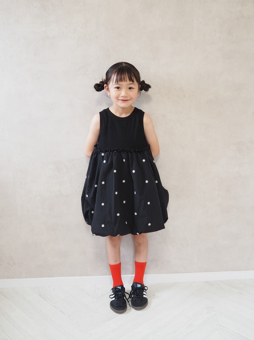 ブラック系のスニーカー、ブラック系のワンピース、レッド系のソックス/靴下を着用したキッズの夏コーディネートの1枚目の写真