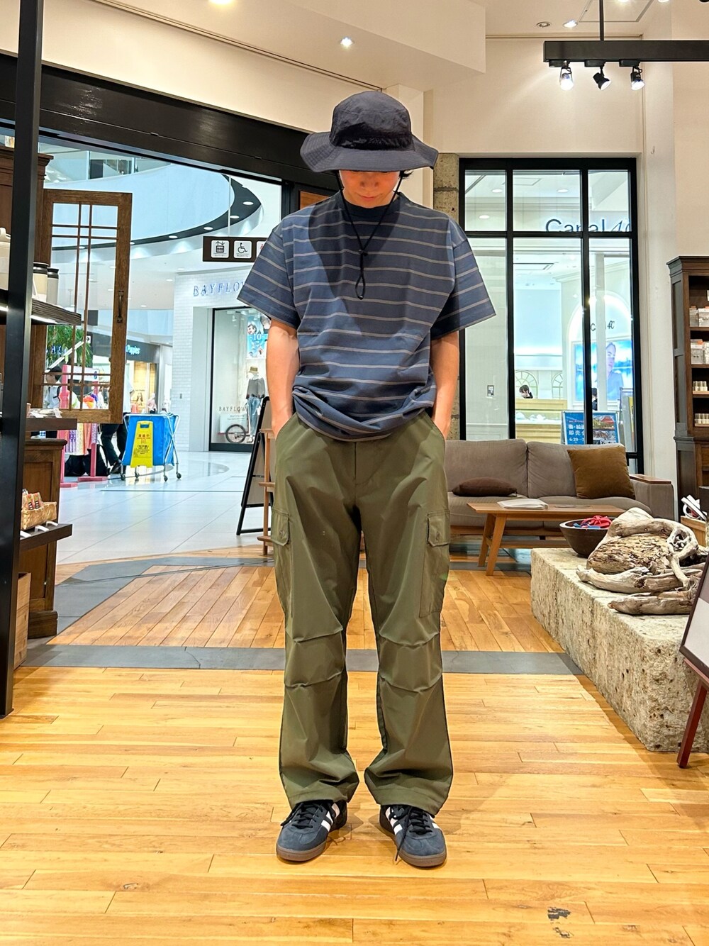 ブルー系のTシャツ/カットソー、グリーン系のカーゴパンツ、ブラック系のスニーカーを着用したメンズの夏コーディネートの1枚目の写真