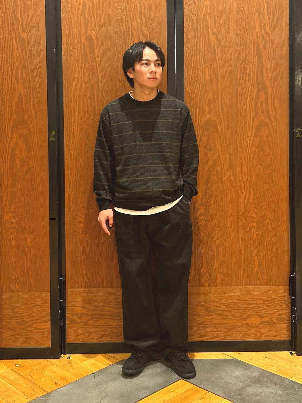 ブラウン系のニット/セーター、グレー系のその他パンツ、ブラック系のスニーカーを着用したメンズの秋コーディネートの1枚目の写真